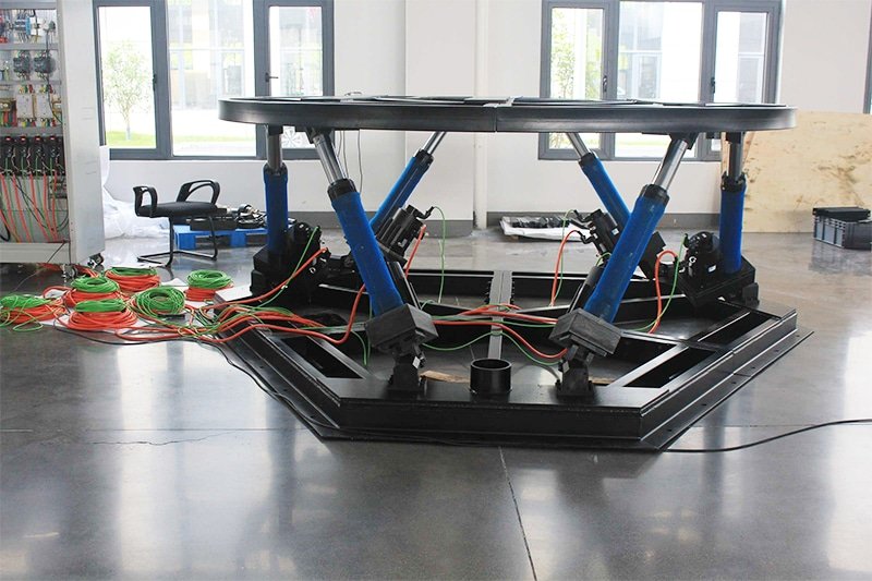 custom six-axis platform on the load-test floor with its control cabinet beside it