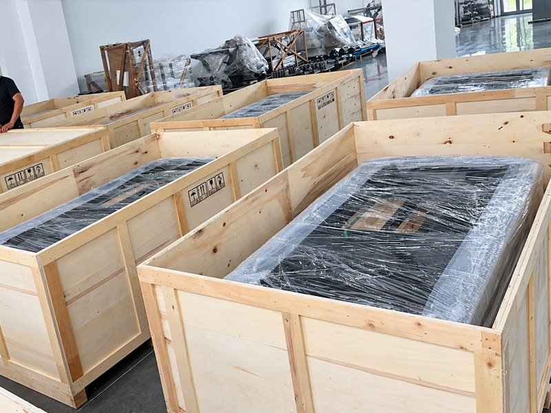 Motion platform components wrapped in protective film inside wooden shipping crates